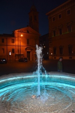 La fontana della piazzetta della Prefettura di Forlì illuminata con i colori LOTO, per la lotta al tumore ovarico