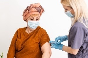 anaziana con maschera chirurgica vaccinata da infermiera bionda